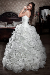 The bride in a luxurious and exclusive wedding dress with an unusual skirt. Waiting for her fiance