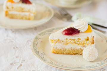 Slice of cake with cream and fruits on white background. Tea time. Selective focus