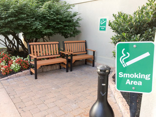 Outddor smoking area designated with benches and flower bed