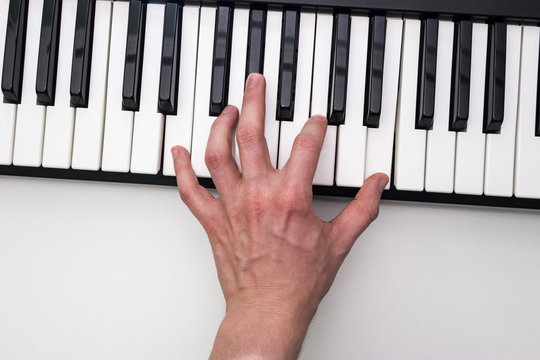 Close-up of the hand of a musical artist playing the piano, a man's hand, classical music, keyboard, synthesizer, pianist.