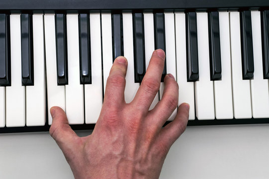 Close-up of the hand of a musical artist playing the piano, a man's hand, classical music, keyboard, synthesizer, pianist.