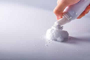 Moment close-up of hand pressing out shaving foam