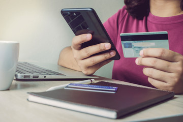 girl's hand holding smartphone and using credit card for online  shopping,online payment.