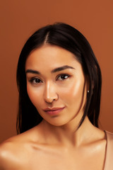Naklejka premium young pretty asian woman cheerful smiling posing on warm brown background, lifestyle people concept