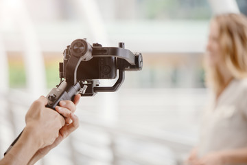 motorized gimbal, videographer using dslr camera anti shake tool for stabilizer record video scene.