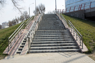 Steps, rampant, a staircase with handrails, railings, descent and ascent for people with disabilities and prams, bicycles.