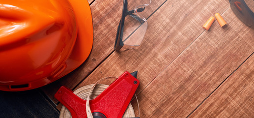 Construction site safety. Protective hard hat, headphones, ruler, glasses and masks on wooden background, copy space