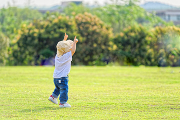The little boy in a hat in the outdoor lawn

