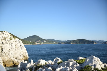 Fototapeta na wymiar 白い岩壁と緑の対岸