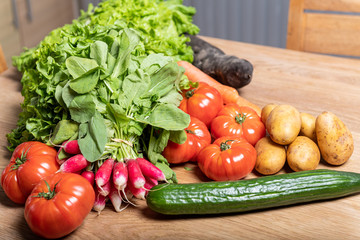 Varied organic vegetable harvest on a wooden kitchen table