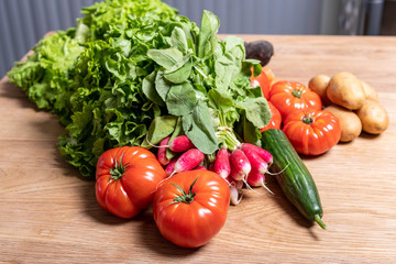 Varied organic vegetable harvest on a wooden kitchen table