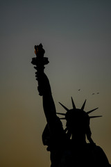 Statua wolności, na tle zachodu słońca.