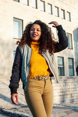 Fototapeta premium young pretty afican american girl happy smiling on city background, lifestyle people outside