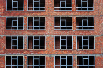 Windows frame in brick multistory house under construction