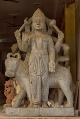 Fototapeta na wymiar A carved stone statue of a Hindu God standing in the entrance of a shop in Delhi