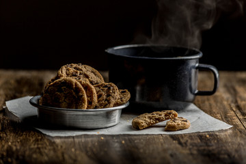 cup of steaming tea with chocolate chip cookies