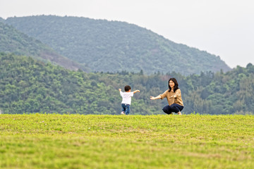 Fototapeta na wymiar Mother and son play on the lawn