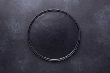 Empty ceramic plate on dark stone background Copy space Top view