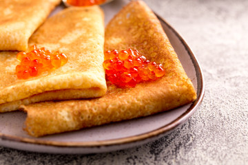 Traditional Russian pancakes with red caviar. Fried crepes with caviar and sour cream