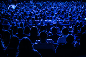 The audience in the cinema, the view from the back. Group of people at the business conference,...
