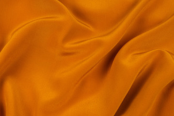 Golden silk or satin luxury fabric texture can use as abstract background.