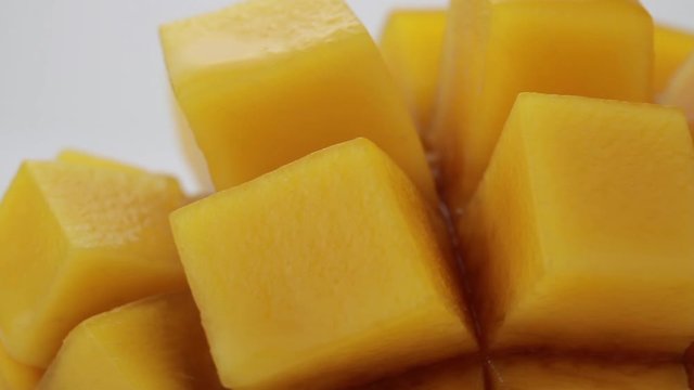 Ripe mango cube slice rotating on white background, Mango juice and tropical fruit product concept.