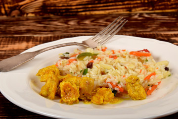 colorful rice with vegetables and pieces of chicken in a curry spice