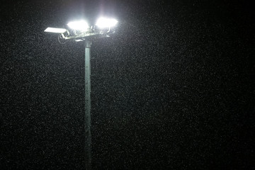 It rains at night on the background of lights.