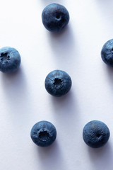 many ripe blueberries on a white background