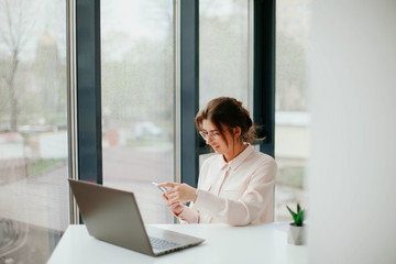 young businesswoman working on laptop in the office. portrait of businesswoman. working in the office. happy business woman talking on the phone in the workplace. 
focused woman working. 