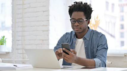 Young African Man using Smartphone in Office