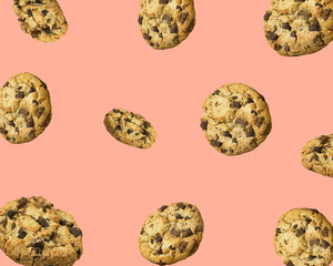 Pattern from homemade chocolate chips cookies flying in air on pink background. Baking kids birthday party sweets concept. Banner poster for cafes coffee shops with copy space