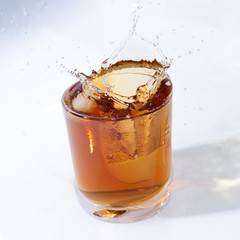 whiskey cocktail with cola and ice in a transparent glass with beautiful splashes
