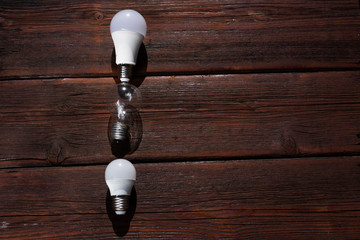 three light bulbs on a wooden background, three old used light bulbs
