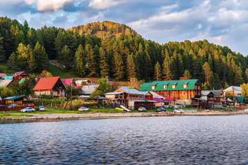 Fototapeta na wymiar Artybash village, Lake Teletskoye, Turochaksky district, Altai Republic, Russia - September, 20, 2019: Village on the shore of a mountain lake