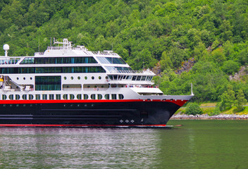 Small Hurtigruten post ship or cruise ship liner or cruiseship MS Trollfjord in Norwegian Geiranger...