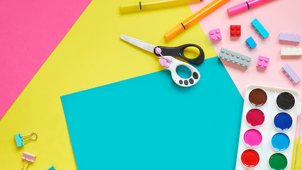 School supplies, stationery on yellow background - space for caption. Child ready to draw with pencils and make application of colored paper. Top view.