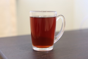 The cup of hot tea on the tablee