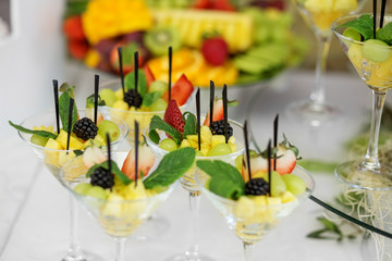 Fruit mix with pineapple, strawberries and blackberries and mint on the festive table. The concept of food, catering, restaurant and celebration.