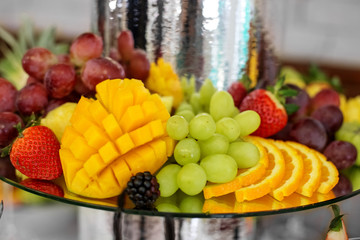 Fruit mix with orange, strawberry and blackberry, mango and grape. The concept of food, catering, restaurant and celebration.