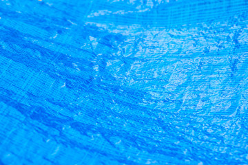 Close up of a vibrant blue Tarpaulin pool cover.