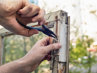 Repairing blocked wooden window hinge with hands