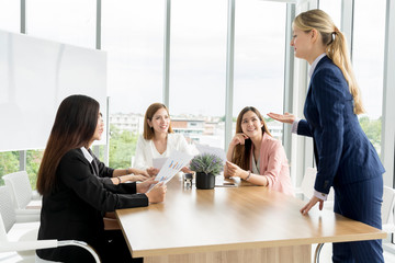 Attractive business woman, teacher or mentor coach speaking or gesturing and discussing something to young people teaching audience at training seminar finance and marketing, new normal after covid-19