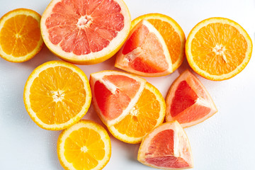 Fototapeta na wymiar Slices of fresh orange and grapefruit on white background top view. Citrus Juice Concept, Vitamin C, Fruits. Creative summer background