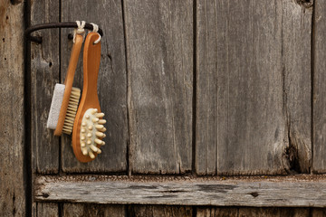 Bath brush on a gray wooden background. Spa pampering in the sauna or bath. Dry body massage