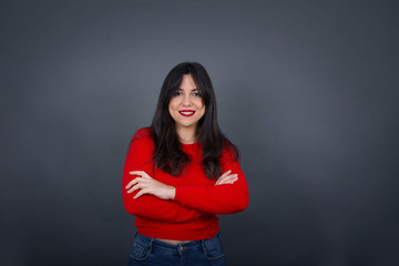 Obraz premium Brunette girl happy face smiling with crossed arms looking confident at the camera standing against gray wall. Positive person.