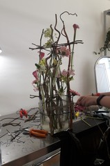 Florist at work. Creating a flower arrangement in a floral vessel. Setting flowers in test tubes.