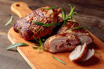 Smoked chicken  thighs with rosemary on a cutting board.