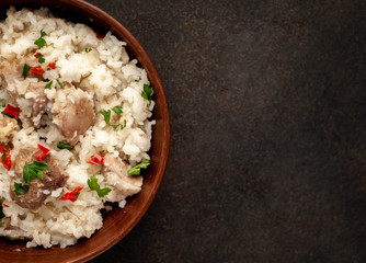 Homemade pilaf with meat and spices in a bowl on a stone table with copy space for your
 text. Oriental cuisine.