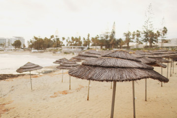 beautiful straw umbrellas on the beach on the empty beach, bright blue water and sky, paradise tropical beach,relaxing time,,amazing view,no people, sunset background. selective focus